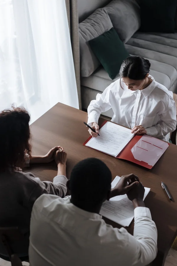 Drie mensen aan tafel bij het ondertekenen van een contract