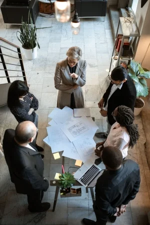 Overleg rond een tafel met tekeningen en documenten
